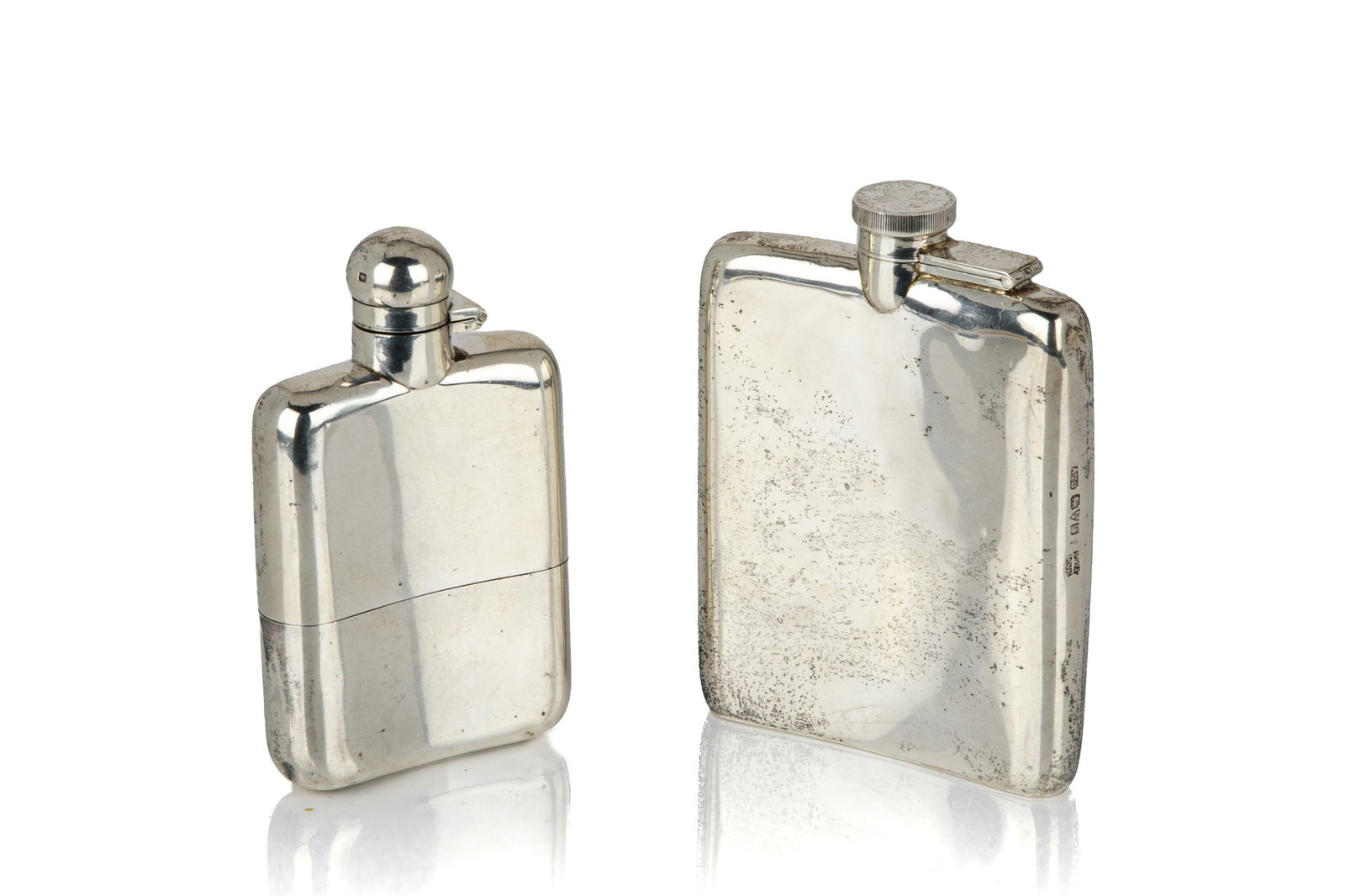 TWO ENGLISH SILVER DRINKING FLASKS: Pair of sterling silver drinking flasks. One with a detachable, gilt washed cup and marks for Sheffield, 1936, makers James Dixon & Sons Ltd.. Another larger one with marks for Chester, 1915,makers As