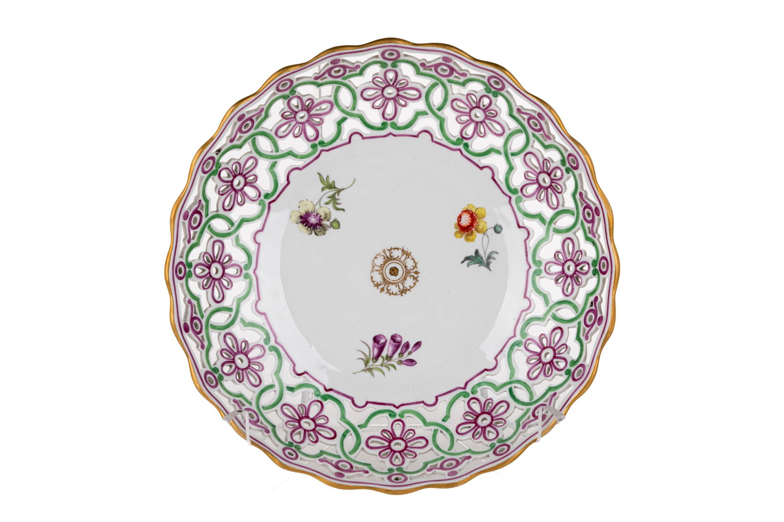 PIERCED PORCELAIN MEISSEN DISH: Pierced porcelain Meissen dish with purple, green, and gilt detailing along the rim and face of the bowl. Hand-painted floral sprays at the centre with a gently scalloped rim. German, 19th C. Dia.: 22