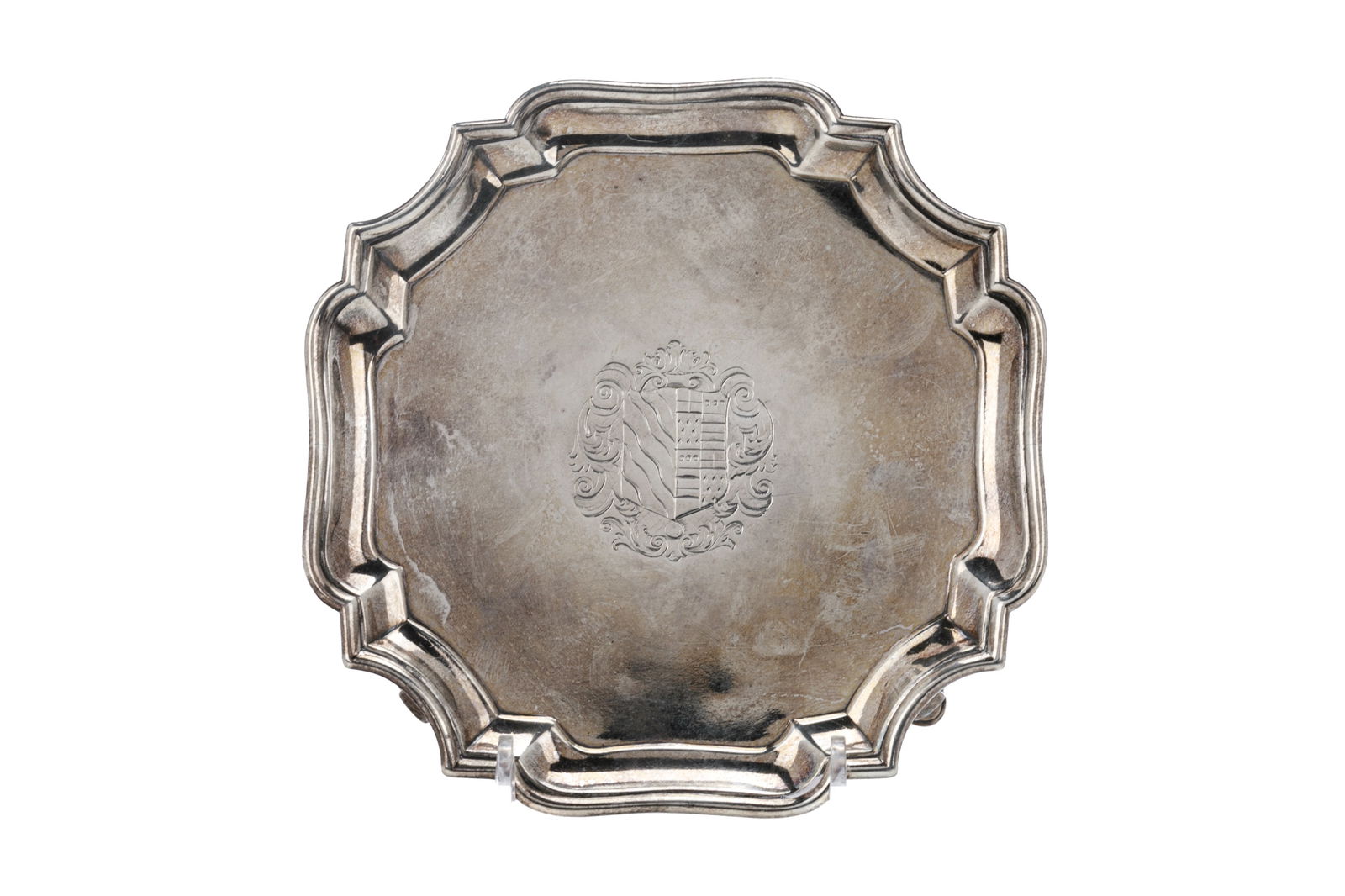 GEORGE II ENGLISH SILVER SALVER, 176g: A sterling silver squared salver resting on four feet with a pie crust border. The center engraved with a small armorial. Marks for London, 1730, makers Robert Abercromby and George Hindmarsh. Dia.: 1