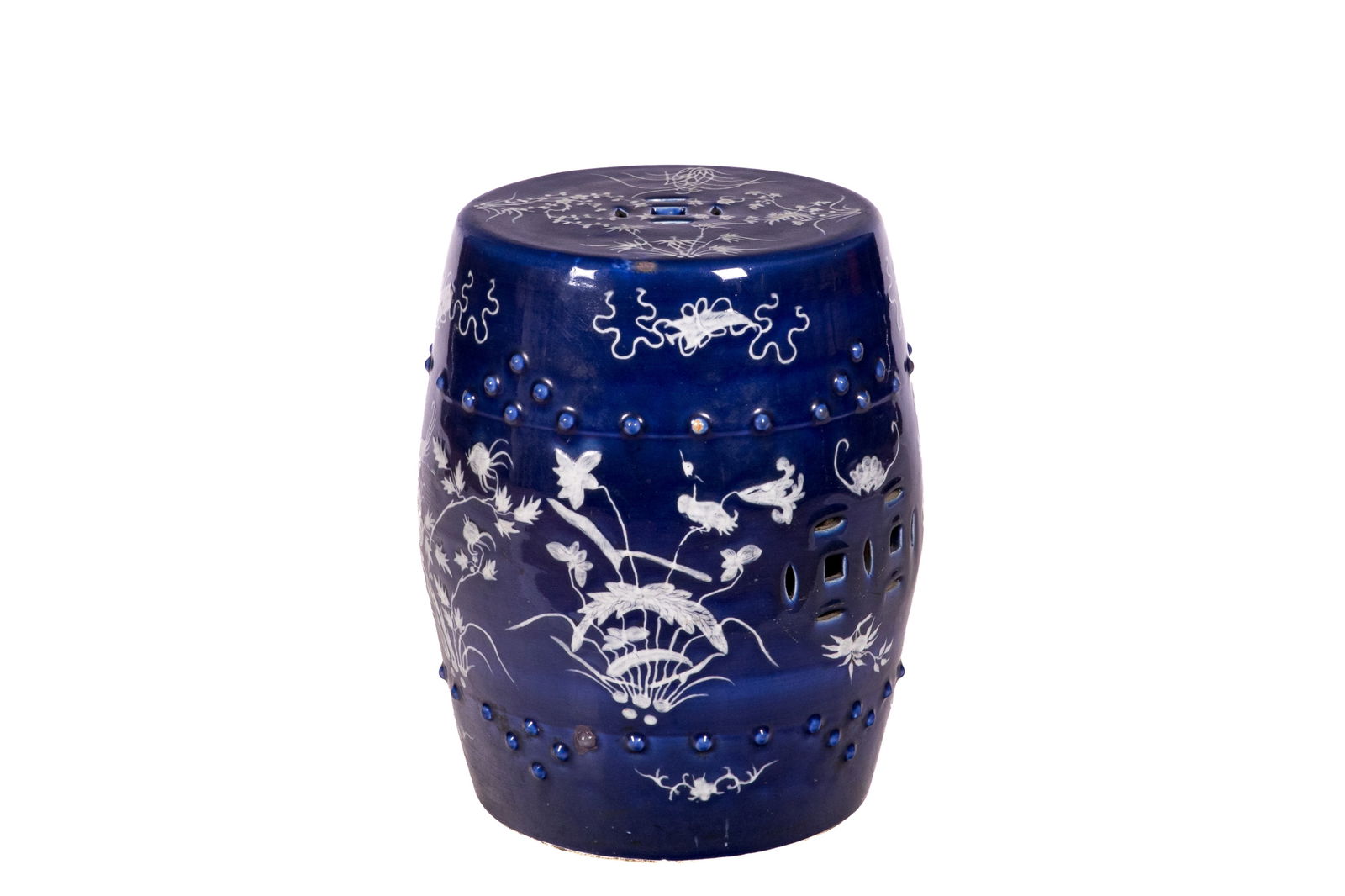 BLUE AND WHITE PORCELAIN GARDEN STOOL: Of barrel form, slip decorated with bird and flower motif on the seat and sides, with raised studs in the upper and lower registers. The body and top with coin-shaped medallion in openwork. H. 47 cm (