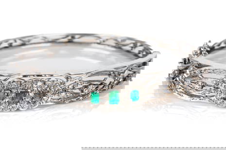 GOLD & DIAMOND ANTIQUE BRACELET, 19.2g: Testing as 14k white gold, the hard bangle bracelet set with diamonds and emeralds. 19.2g total weight.