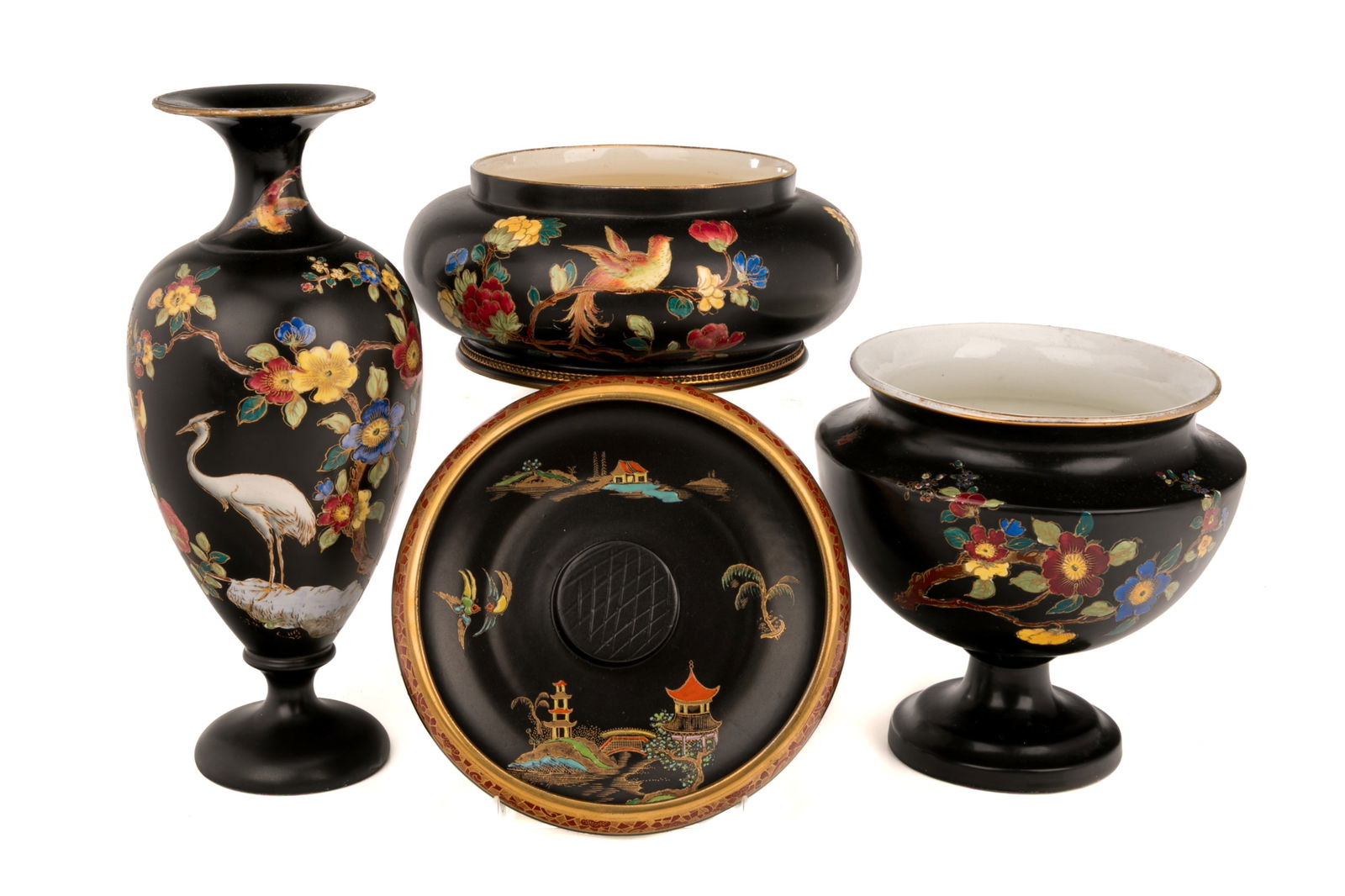FOUR CARLTON WARE PIECES: Group of four Carlton Ware items including one nutcracker bowl, one urn, one baluster form vase, and one rounded bowl. All on black ground with cloisonne-style designs depicting various birds, floral
