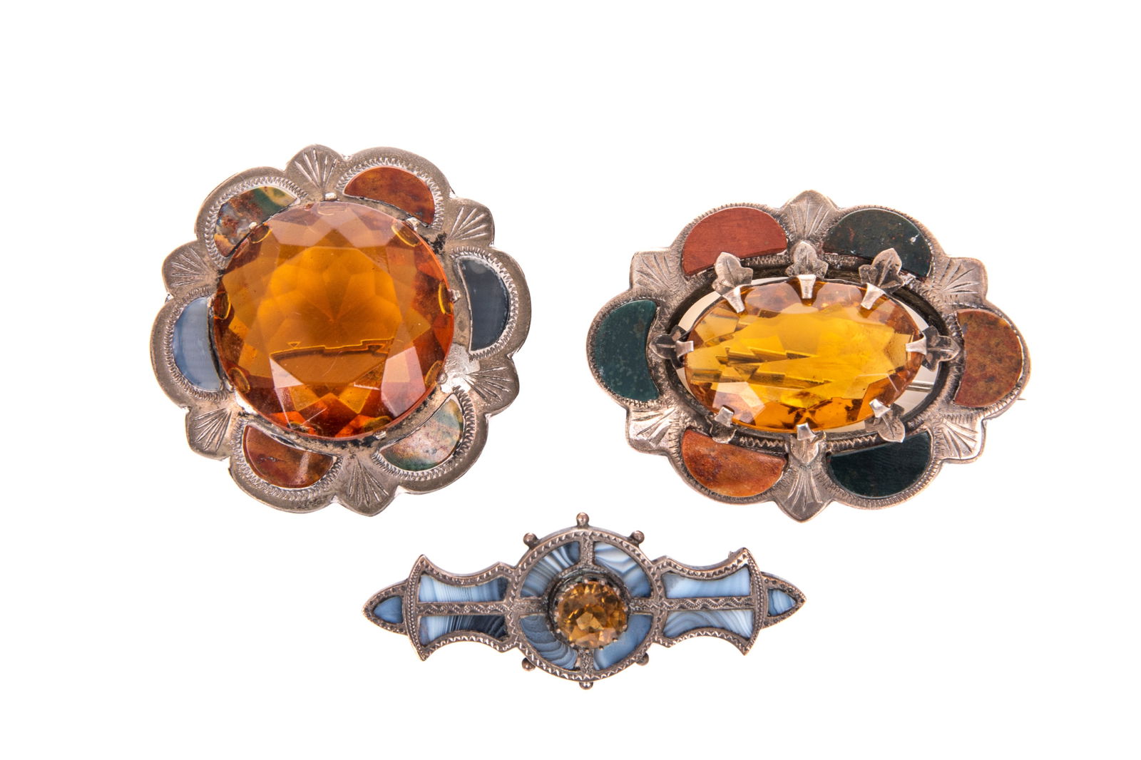 THREE SCOTTISH SILVER & MIXED STONE KILT BROOCHES: Set with mixed agate and cairngorm stones. Late 19th / early 20th C.