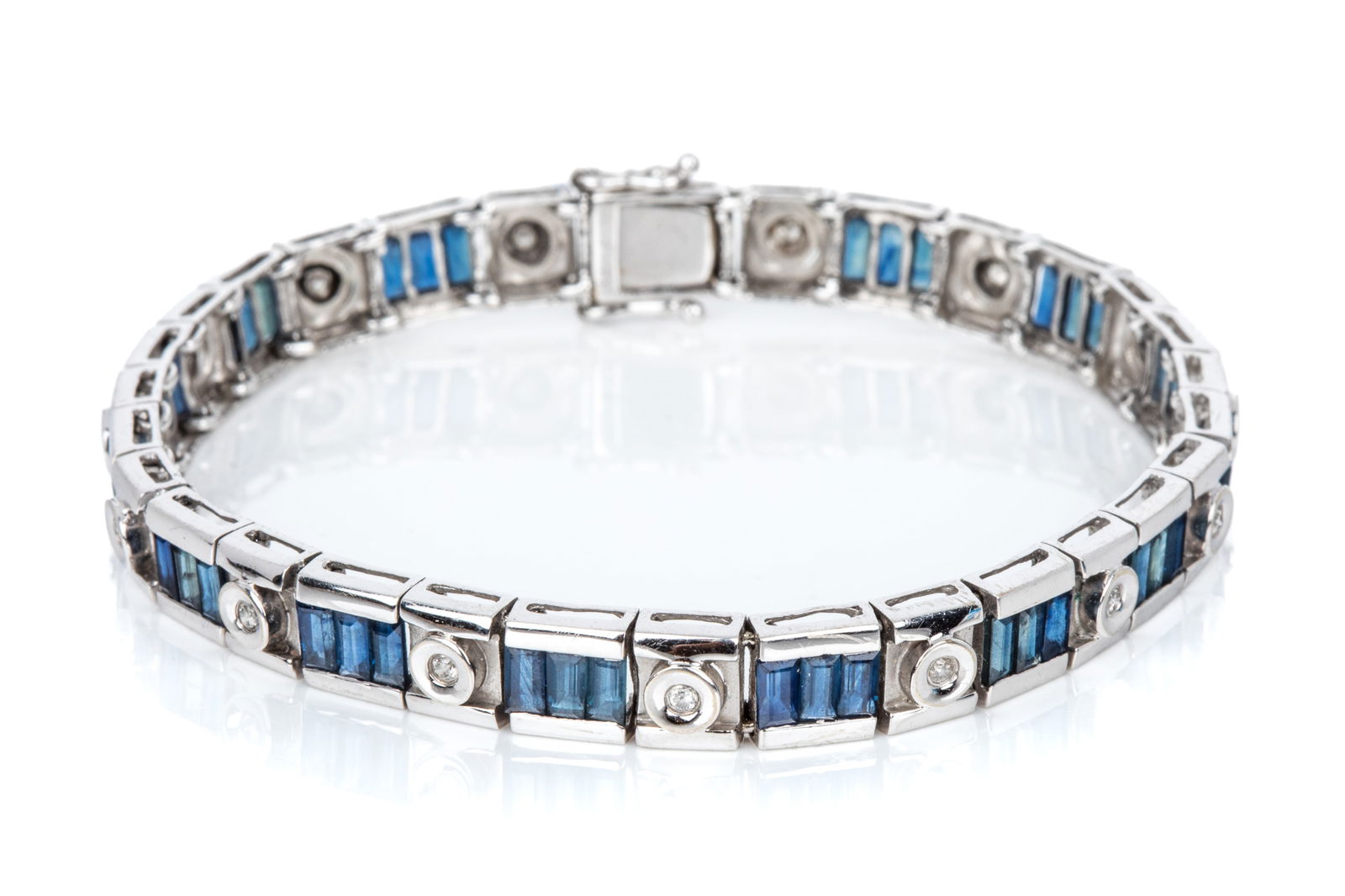 14K DIAMOND & SAPPHIRE TENNIS BRACELET 16.4g: 14K white gold 7 inch long tennis bracelet equipped with box catch and 2 side catches The bracelet features channel set baguette step cut blue sapphires of moderate qualityAccented with round brillian