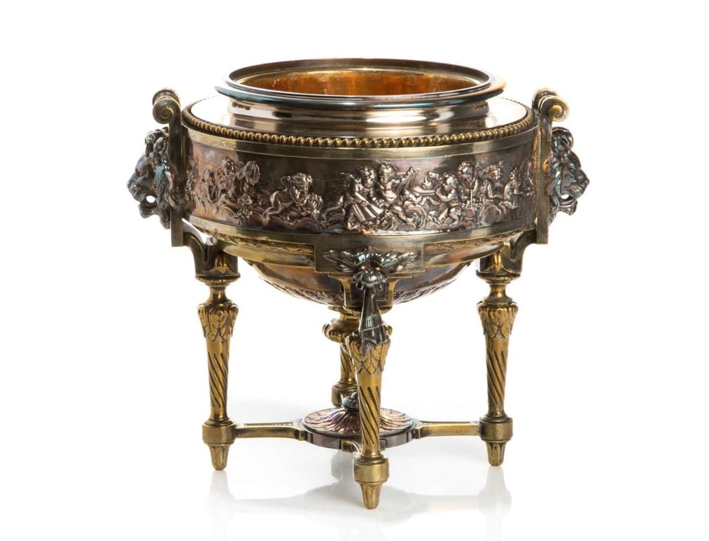 MAISON MARNYHAC SILVERED BRONZE CENTERPIECE: Wine cooler, cast in sections with figural relief panels and lion mask handles on four legs. French 19th C.