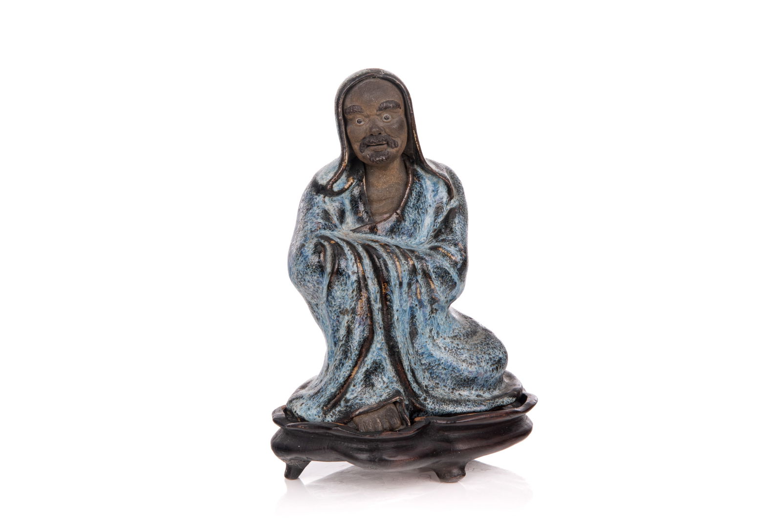 CHINESE SHIWAN POTTERY FIGURE OF DAMO: Depicted a seated Damo in long blue glazed robes. On fitted carved wood stand. H. (without stand) 16 cm