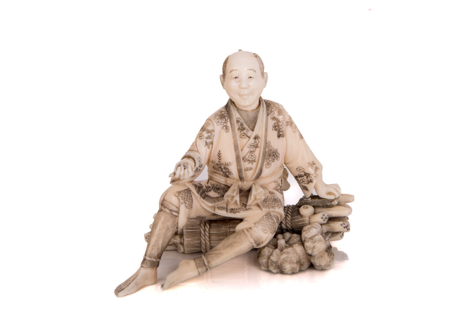 OKIMONO OF A MALE SELLER: Depicting a male seller in robes sitting on a pile of possibly sugarcanes. Signed "Yukikazu" to the underside in red cartouche.H.: 6.5 cm (2 1/2 in.) CITES