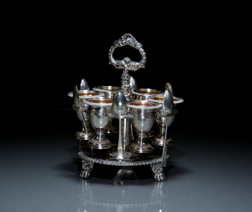MATTHEW BOULTON SHEFFIELD PLATE EGG CRUET: Circular frame on tripod feet with six gilt washed egg cups, later silver spoons. H 21 cm. (8 1/4 in.)