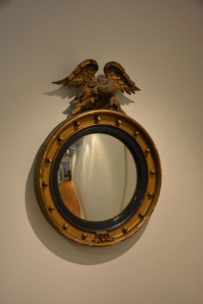 AMERICAN FEDERAL BULLSEYE MIRROR: Carved and gilt wood eagle finial with convex mirror, 19th cen. H 31 x 23 in.