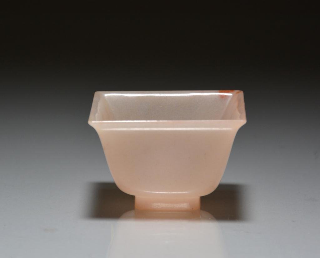 CHINESE SQUARE AGATE MUGHAL WINE CUP: Finely carved cup with flared mouth, of a translucent light-orange stone. W. 5.5cm (2 1/4 in.)