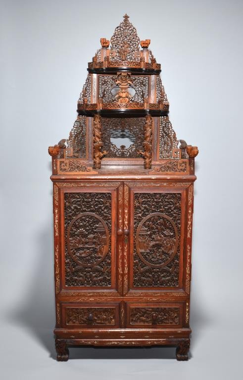 CHINESE CARVED WOOD FIGURAL CABINET: Pierced fretwork paneling with figures, dragon-form columns under leveled display stands with carved foliage back, ivory-inlaid borders, on dragon-head claw feet. 19th century. H. 131cm (51.6 in.) DIS