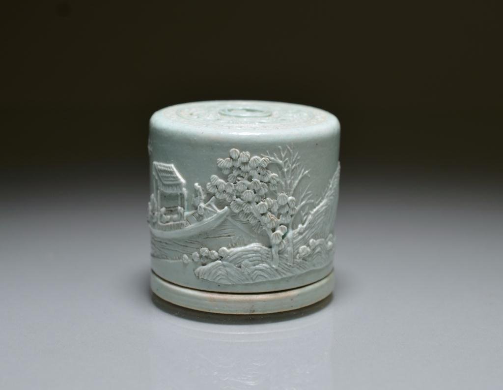 CARVED PORCELAIN INCENSE HOLDER BY WANG BINGRONG: Pierced lid with a carved continuous landscape scene in pale green glaze, interior is celadone-glazed. The base has four-character mark Wang Bingrong zuo." H. 6cm (2 3/8 in.) Provenance: purchased dur