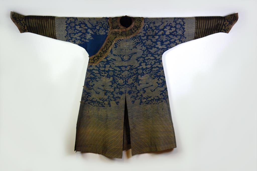 CHINESE IMPERIAL SUMMER ROBE: Silk and linen brocaded five-clawed dragons in gold-colour thread on navy ground, with cranes and various Buddhist emblems. 19th century. L. 128cm (50.5 in.)