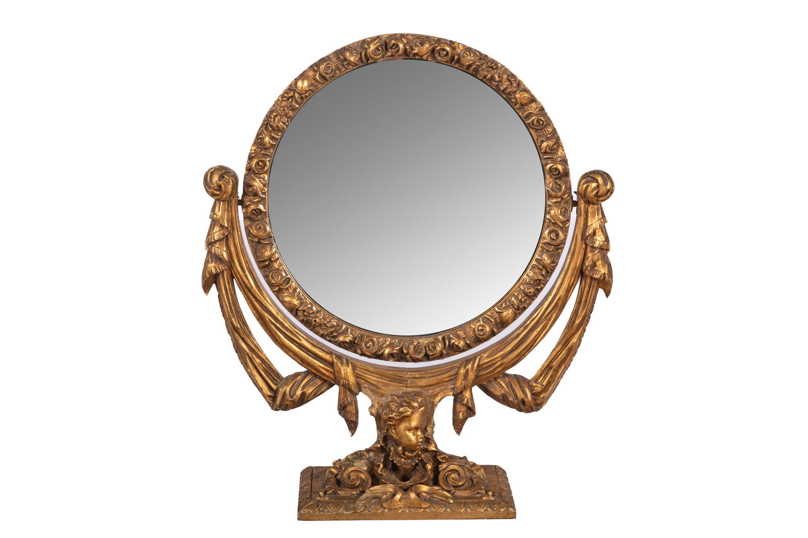 CARVED GILTWOOD TABLE MIRROR: Ribboned base with a central putti head and squared support, probably Italian, early 20th C. H 27 1/2 X W 24 1/2