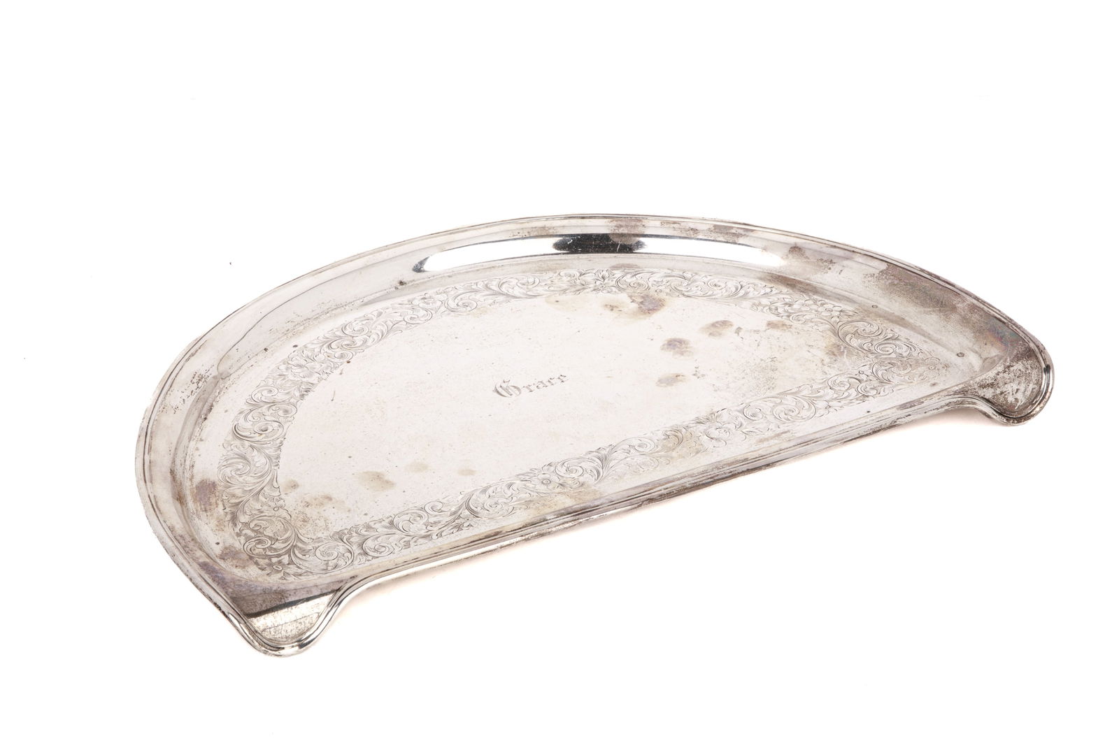 BIRKS CANADIAN SILVER HIGH CHAIR TRAY, 844g: A very unusual Birks sterling silver high chair tray. The semi circular tray with integral clips is engraved with a floral band of decoration and the name Grace in the centre. Dated 1930. Weight
