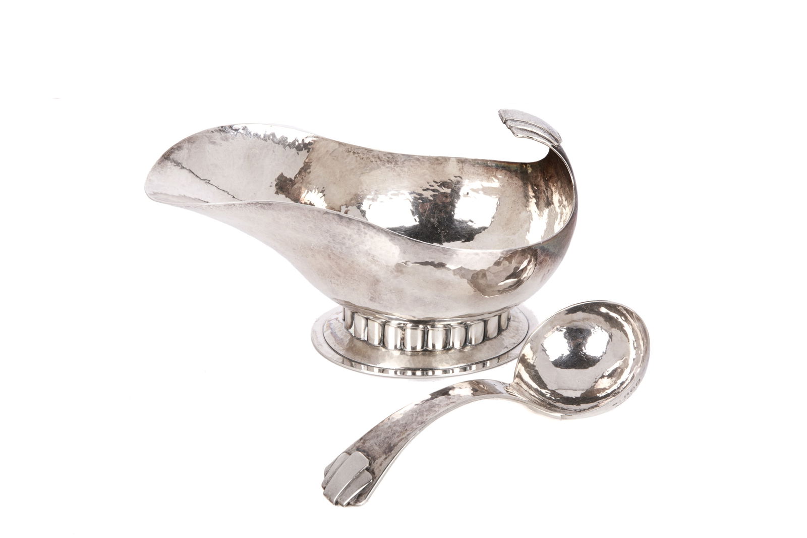 CHARLES BOYTON SILVER SAUCE BOAT AND LADLE, 233g: An English sterling silver Art Deco sauce boat and ladle from the studio of renowned silversmith Charles Boyton Hallmarked for London 1947. Each piece also bears a facsimile of his signature.The