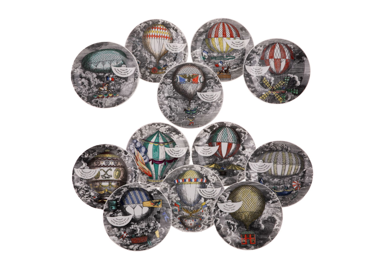 TWELVE FORNASETTI ITALIAN PORCELAIN PLATES: The Mongolfiere series, each with a different hot air balloon, dated 1955. Dia 24cm (9 1/2in)