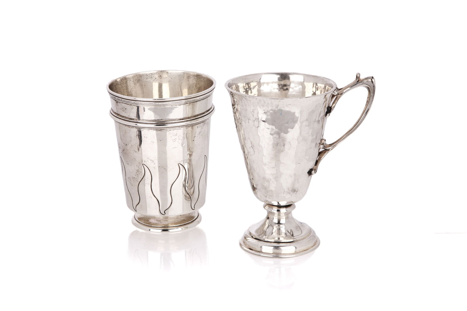 TWO STYLIZED ENGLISH SILVER CUPS, 321g: An English sterling silver beaker by Carrington, London 1906. The beaker is chased with a repeating flame design. Together with a footed cup a\with applied cast handle, Chester 1914, Hamilton andCo. T