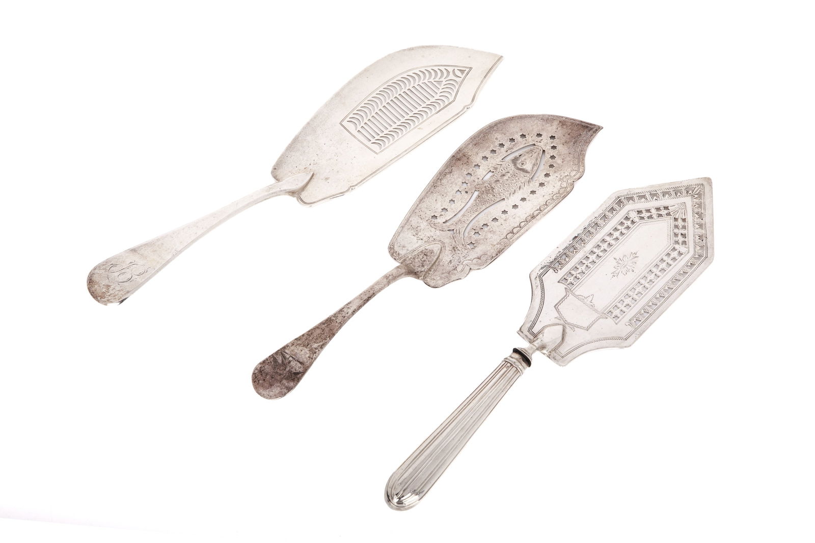 THREE ENGLISH SILVER FISH SLICES, 290g: Three English sterling fish slices dated London 1792, 1814, and one Exeter 1843. All with pierced blades the early one has a hollow handle.Weighable 290 G. Length 30 Cm.
