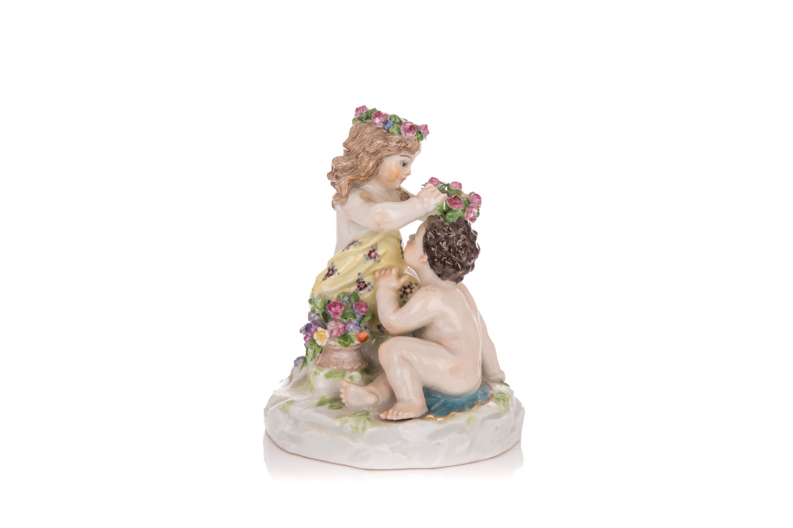 MEISSEN PORCELAIN FIGURAL GROUP OF FLOWER GIRL: Depicting a young girl placing a flower wreath on top of a naked boys head, Cross swords mark. H. 4 1/4"