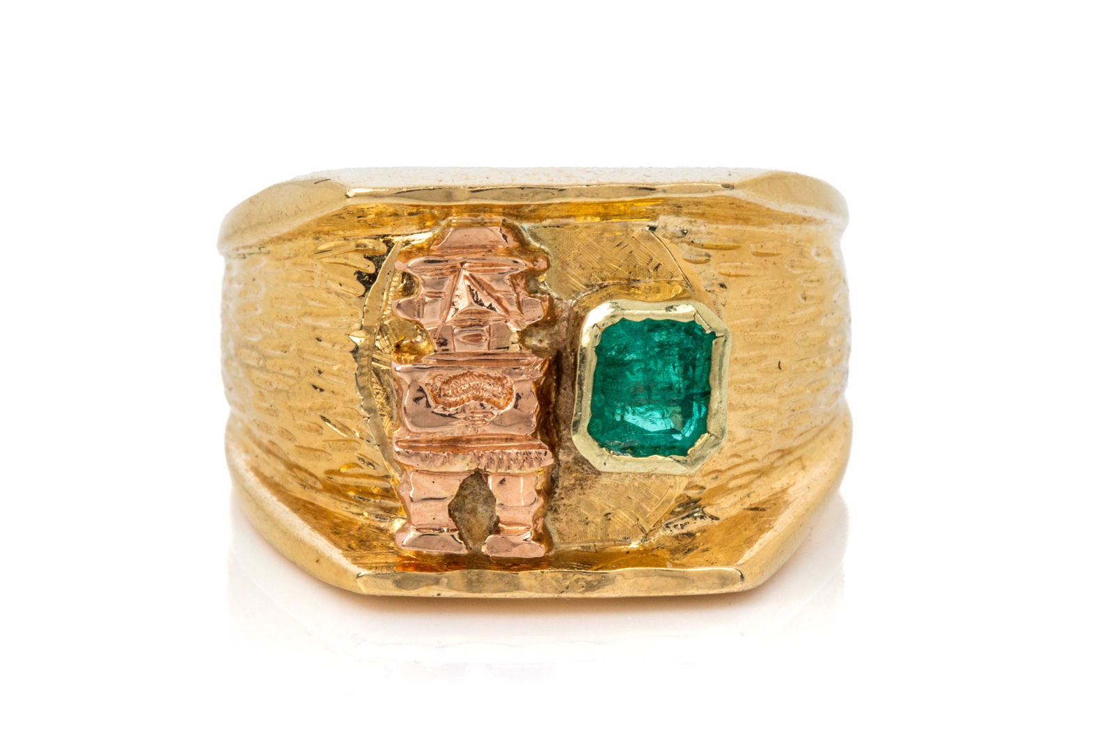 18K PRE-COLUMBIAN STYLED EMERALD RING 15.5g: Yellow gold ring testing approximately 18K measuring 14.2mm wide, decorated with a rose gold pre-Columbian styled figure. Featuring emerald cut natural medium very slightly bluish green emerald modera