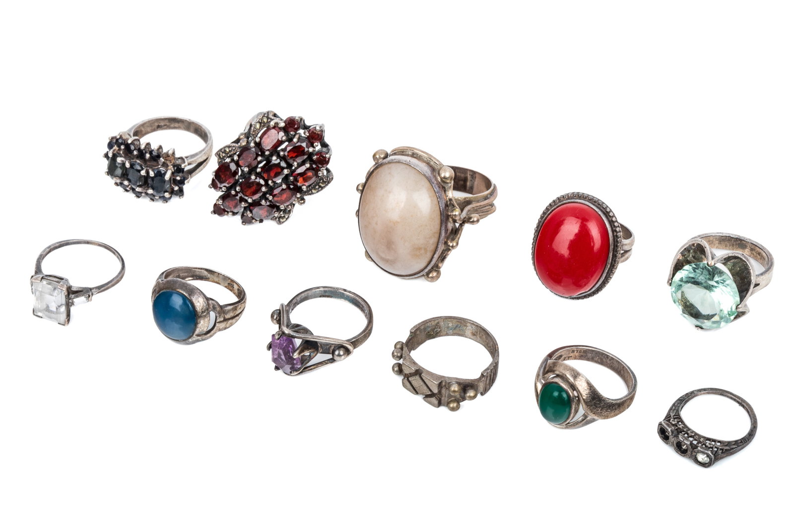 SILVER RING GROUPING 80.9g: Mexico silver amethyst ring. Size 7 4.6 grams 925 silver statement ring with garnets andmarcasites, measuring 35.5mm long. Size 7 13.2 grams 3 rings stamped 925. 20.6 grams3 rings stamped sterling. 9.