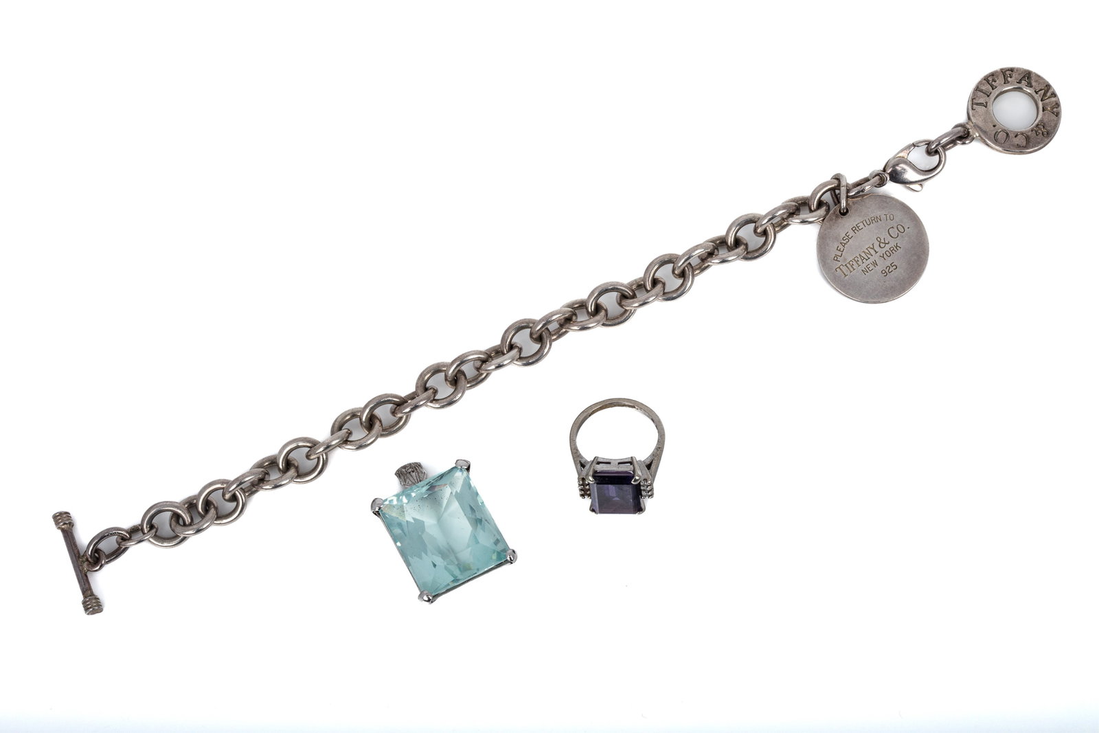 10K GEMSTONE RING & PENDANT, SILVER BRACELET 63.8g: 10K white gold ring with imitation amethyst gemstone with colourless round faceted accents. 5.6 grams. Size 6White gold pendant testing approximately 10K Featuring 1 rectangular faceted pale blue imit