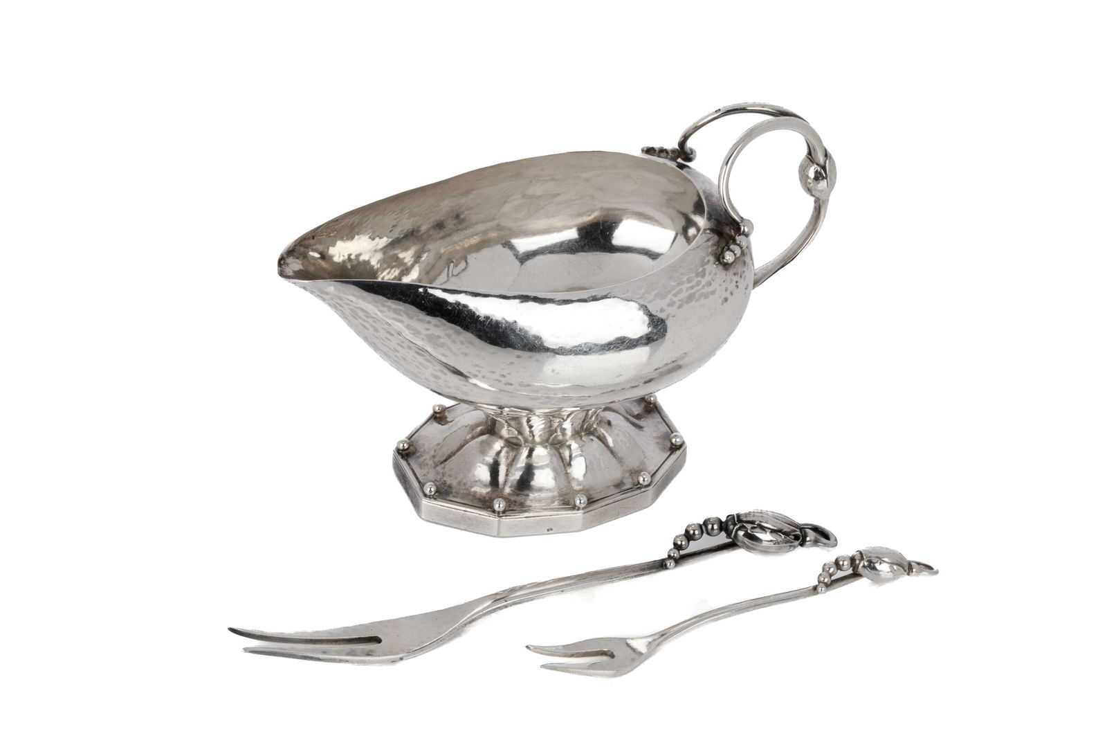 ART DECO GEORG JENSEN SILVER CREAM SAUCEBOAT, 138g: A sterling silver gravy boat by Georg Jensen. In the blossom style, pattern 181 the hand wrought body rests on a raised foot with paneled base. Sterling gravy boat two pickle forks 138 grams
