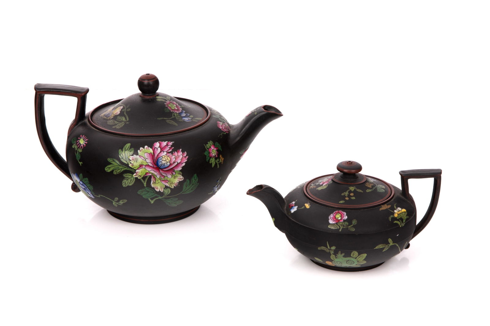 TWO WEDGWOOD BLACK BASALT TEAPOTS: Graduated sizes with floral enamel decoration. Impressed Wedgewood mark to underside. English 19th Century Largest L 8 1/4" (21cm)