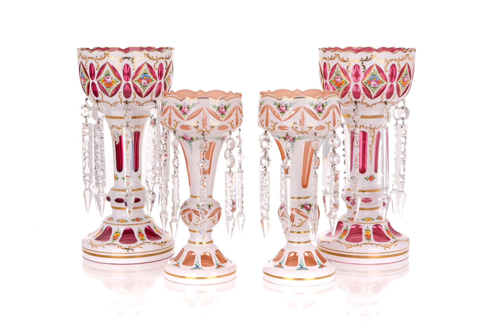 TWO PAIRS OF CASED BOHEMIAN GLASS LUSTRES: In cranberry and peach glass with cased white enamel and floral painting hanging cut glass lustres, 20th C H of cranberry 33cm (13in)