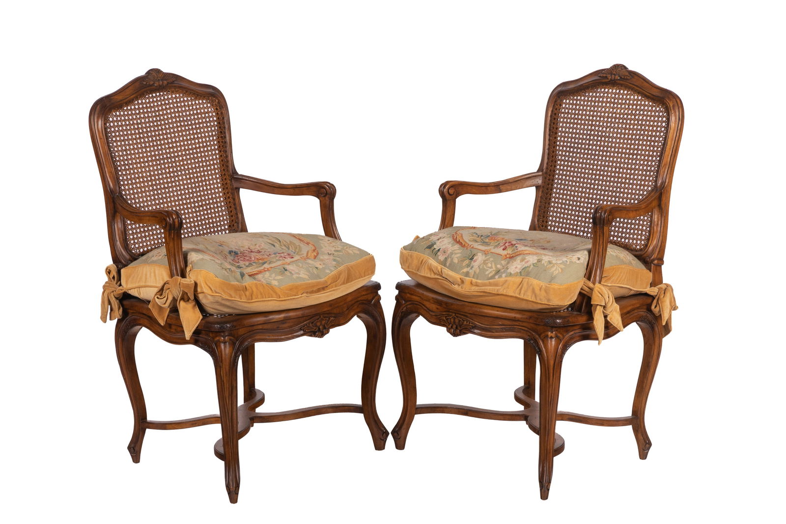 PAIR OF FRENCH CANED BACK ARMCHAIRS: Carved walnut frames with caned seats and French needlepoint upholstered cushions. 20th C. H. 40" x W. 23" x D. 18"