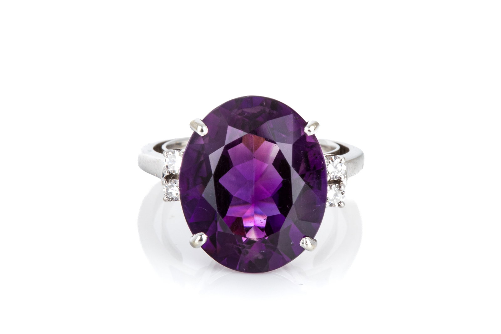 18K WHITE GOLD AMETHYST & DIAMOND RING 5.6g: 18K white gold ring measuring 14.9mm long by 8.5mm tall, equipped with a permanent ring guard to reduce spinning during wear. Featuring 1 oval mixed cut amethyst measuringapproximately 15 x 12.4mm, ey