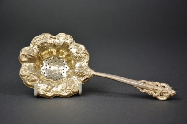 Grande Baroque pattern silver tea strainer, 50 g.: - by Wallace. L: 7 1/4 in.