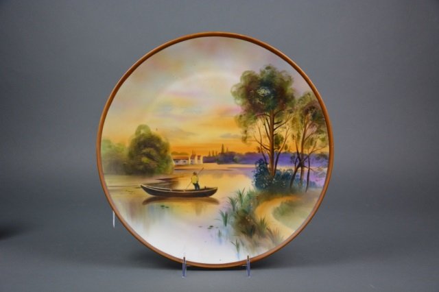 Nippon hand painted plaque: - sunset landscape with a fisherman in boat in the foreground. Green M-in-Wreath, Dia 35.5 cm. (14 cm. )