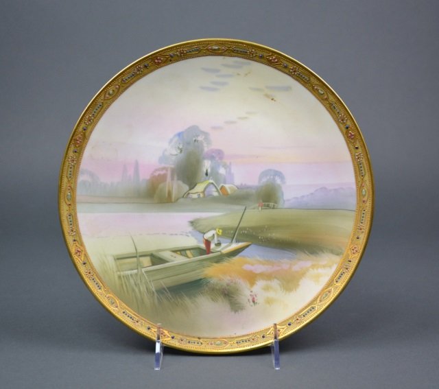 Nippon Porcelain Plaque: - Hand painted with a fisherman in boat and landscape, beaded and gilt border. Green M-in-Wreath. Dia 25.5 cm. (10 in.)