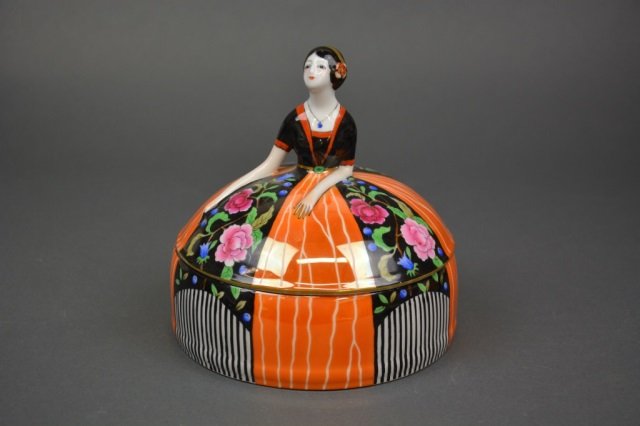 Noritake Art Deco Dresser Jar: - Figural box of a lady in striped and floral dress (restored). Dia 15.4 cm. (6 in.)
