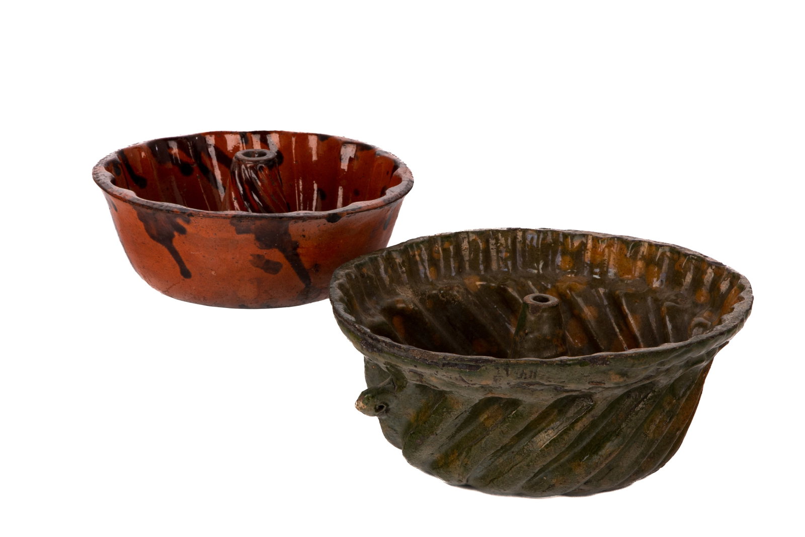 TWO REDWARE TURK'S HEAD MOULDS: One in green mottled glaze, the other red with dark streaks, 19th century. Dia of larger 10 1/2 in 27 cm.