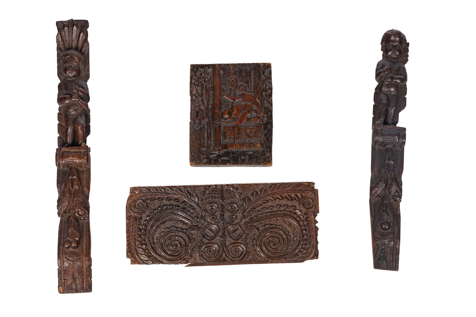 THREE 17th / 18th C WOOD OAK CARVED FRAGMENT: Pair of caryatids that depict figures of cherubs and a carved wooden panel with botanical fern designs.Caryatids H. 25.8in x W. 3in x D. 1.2in (65.5cm x 7.5cm x 3cm) Carved wooden panel H. 17.9in x