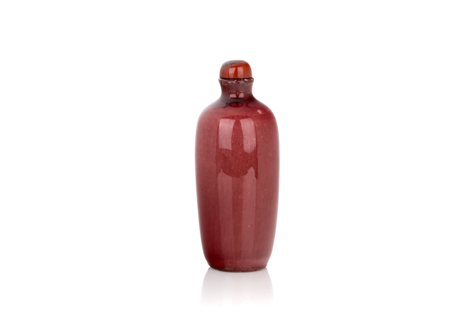 PEACHBLOOM GLAZED PORCELAIN SNUFF BOTTLE: Of barrel form. The body glazed in peachbloom with crackle. Stopper. Qing dynasty, Kangxi period, early 18th century.H. 9 cm Snuff Bottle Collection of John Mckeggie Rogers (1905-1977) He was a senior