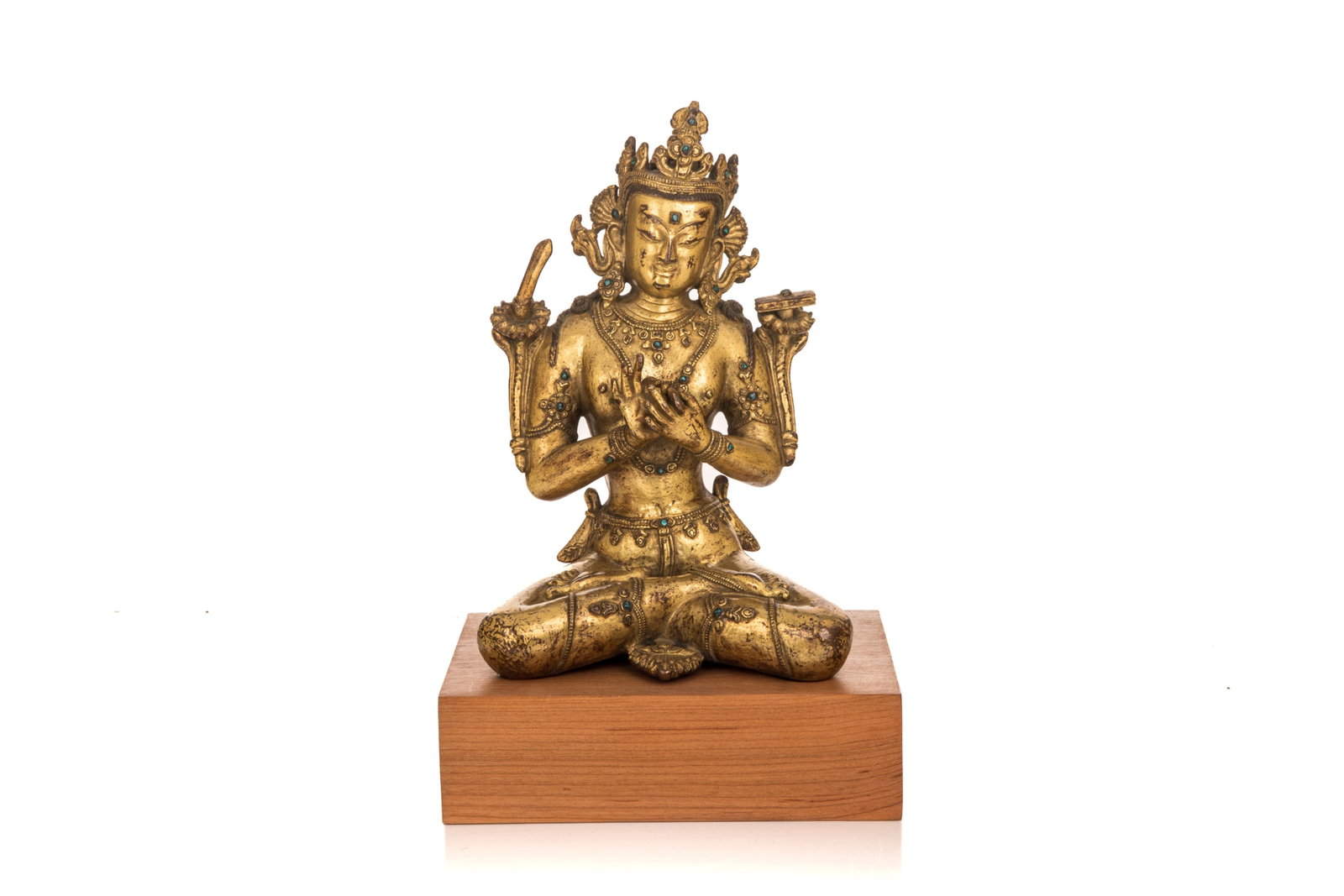 SINO-TIBETAN SEATED GILT-BRONZE MANJUSHRI BUDDHA: Seated in dhyanasana position and hands held in dharmachakra mudra, the Buddha is accompanied with a sword and a scripture. Inlaid with turquoise, on fitted wood base. H. without base 19.5 cm https://