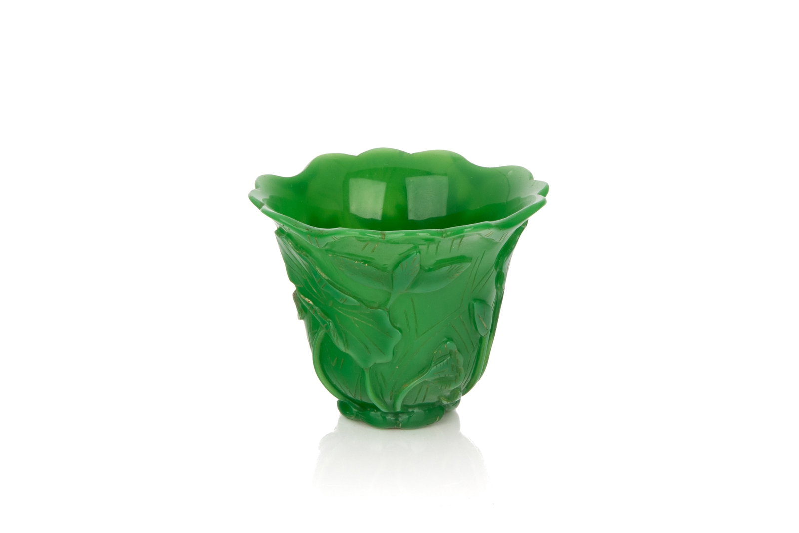 EMERALD GREEN PEKING GLASS LOTUS CUP: Overall in an opaque emerald green, the exterior carved with lotus in relief, the rim shaped like lotus petals, and footring in lotus root form. H. 6.5 cm; diam. 8 cm Collection of John Mckeggie Roger