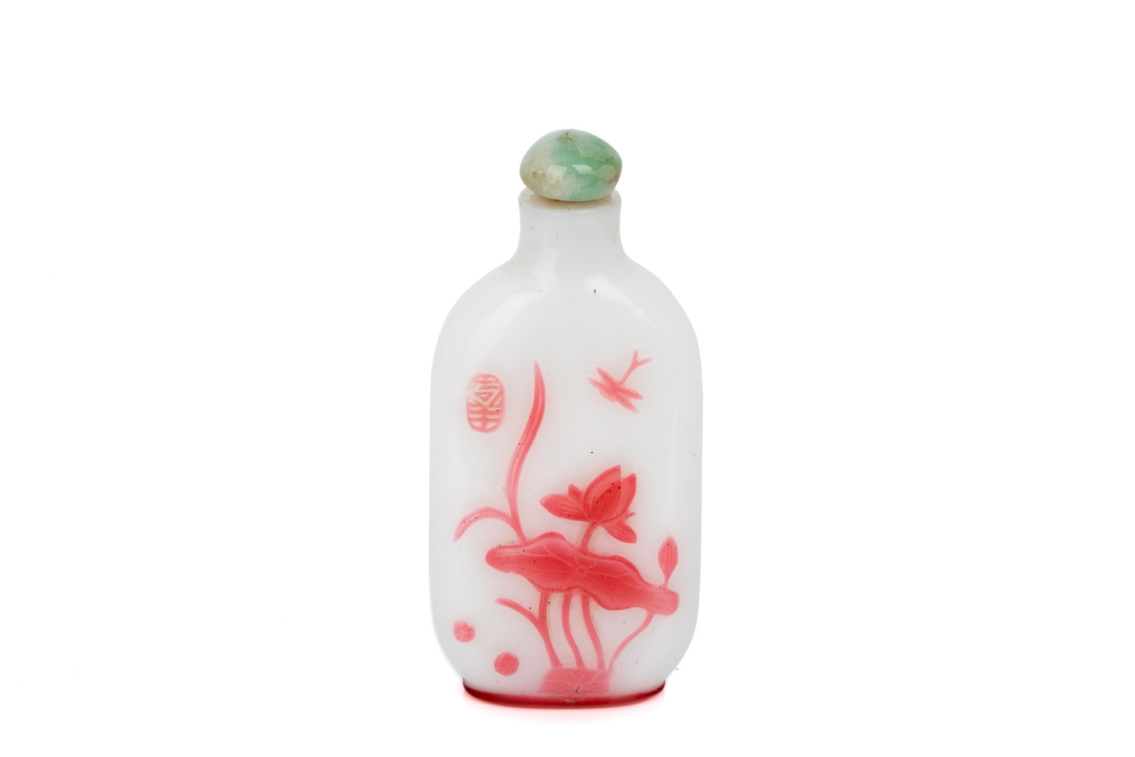 PINK OVERLAY WHITE GLASS LOTUS SNUFF BOTTLE: Of flattened tapered rectangular form. Carved in a rose-pink overlay on a milky white ground with lotus on one side, and ducks in a pond on the other. Jadeite stopper. H. 6.5 cm Snuff Bottle Collectio