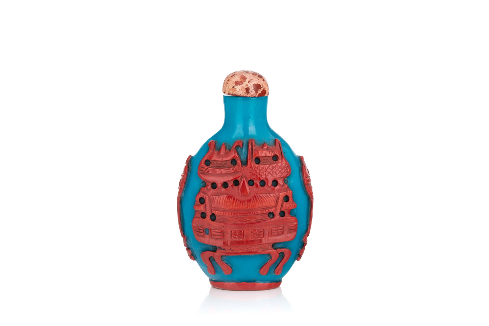 CORAL OVERLAY ON BLUE GLASS SNUFF BOTTLE: Of flattened oval form. Carved in a coral red overlay on a turquoise blue ground with archaic bronzes motif. Jasper stopper. Qing dyansty, 18th century. H. 7.5 cm Snuff Bottle Collection of John Mckeg