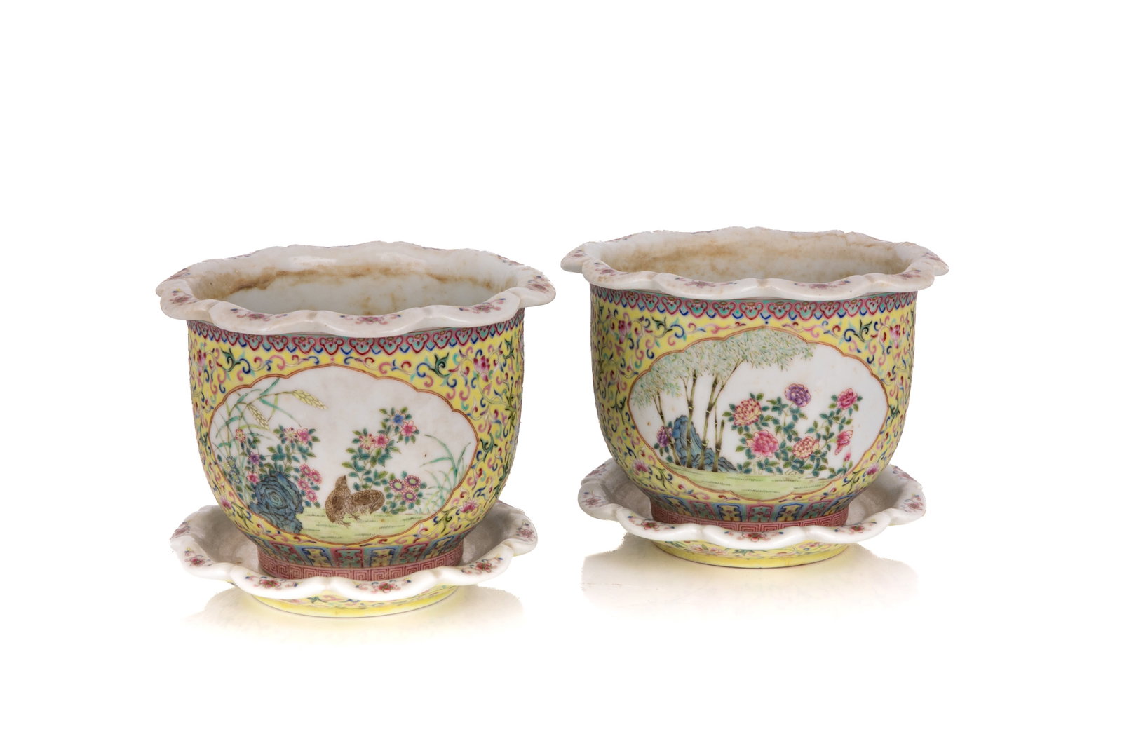 PAIR FAMILLE ROSE YELLOW GROUND PLANTERS & STANDS: The body decorated with two reserved panels depicting bird and flower motif set against a yellow ground with bats and scrolling foliage. The everted lobed mouth rim with floral sprays. Two drainage ho