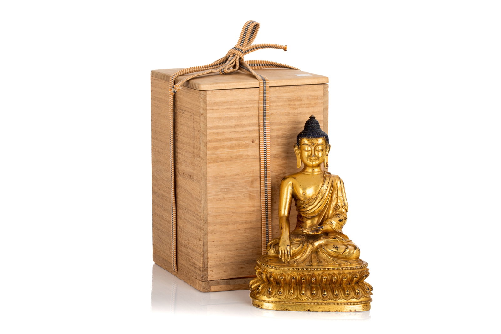 GILT BRONZE SEATED SHAKYAMUNI BUDDHA: Seated in dhyanasana on a double lotus base, his hands in bhumisparshamudra. Six-character Yongle mark incised on top of the lotus base. The underside sealed with a double vajra. With Japanese wooden 