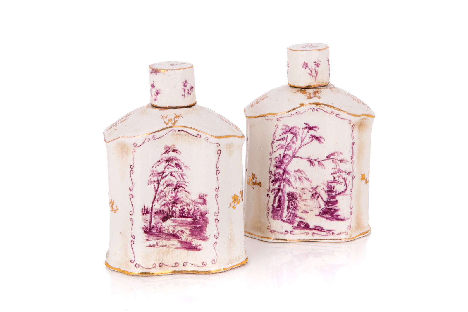 PAIR OF EARLY PORCELAIN COVERED TEA CADDIES: Each of rectangular flask form decorated in monochrome puce, showcasing a central landscape motif depicting a highly detailed pastoral scene with prominent deciduous trees. This motif is framed on eac