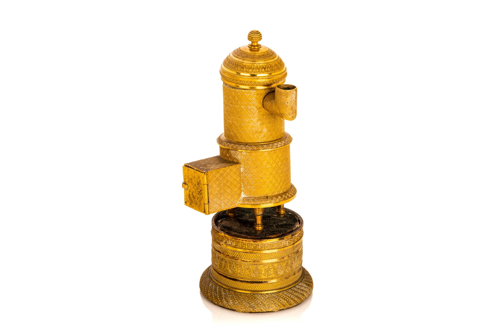 FRENCH EMPIRE GILT BRONZE PASTILLE BURNER: Textured pastille burner with porcelain lined interior, collapsible body in the form of a miniature stove. Together with three gilt brass small chamber sticks, French, 18th C. Stove model H. 6in (15.2