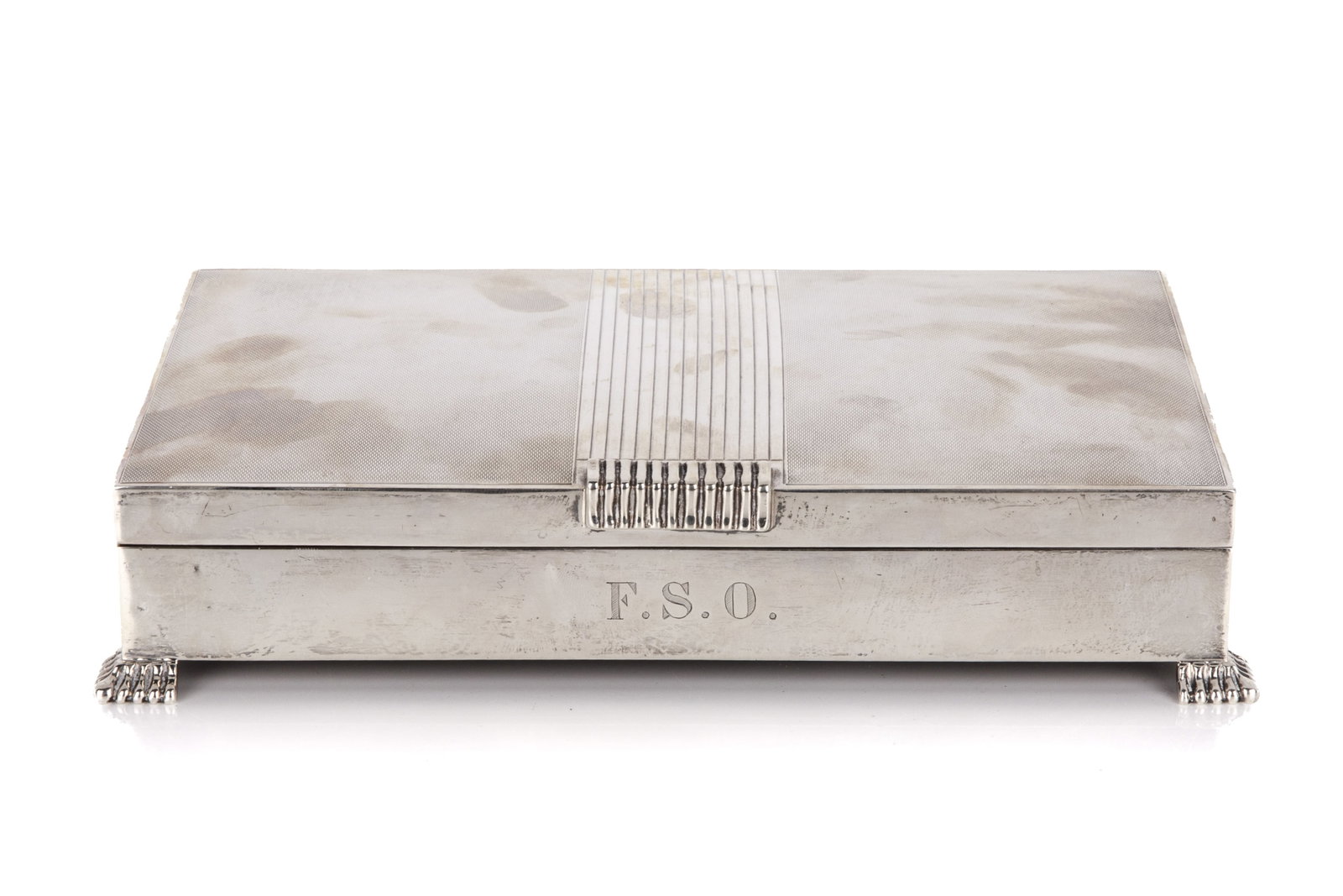 ART DECO STERLING SILVER CIGARETTE BOX, 965g: Cigarette box featuring a hinged lid with a central reeded pattern and an engine-turned design, cedar lined interior. on small silver feet. Initials F.S.O. are etched in the front, potentially for