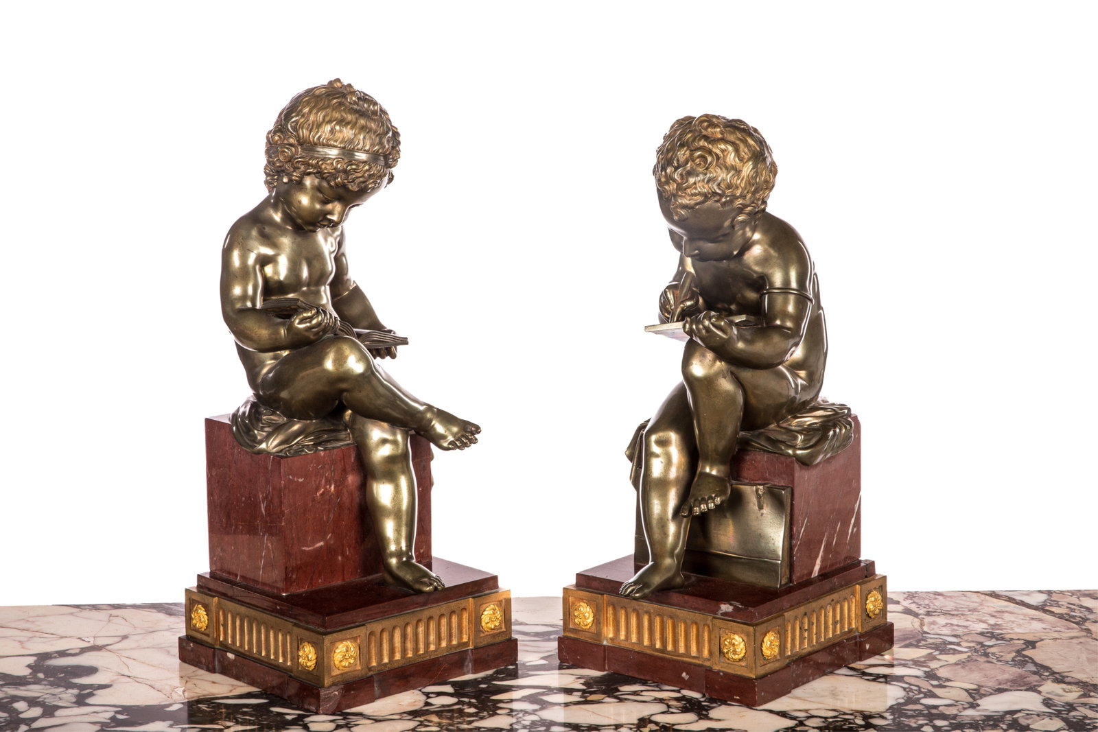 PAIR OF FIGURAL BRONZES ON RED MARBLE BASES: Allegorical figures of two children with book and scribe after Antonio Canova (1757-1822) on stepped red marble bases accented with ormolu mounts, French 19th C. chip to corner of one base. H 18 1/2in