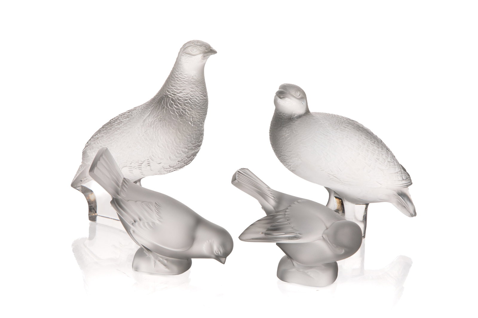 SET OF FOUR LALIQUE GLASS BIRD FIGURINES: Comprising 2 larger Lalique birds, each signed Lalique France to the underside; 2 smaller glass bird figurines. H. 6 3/4in x L. 6in (17.2cm x 15.2cm)